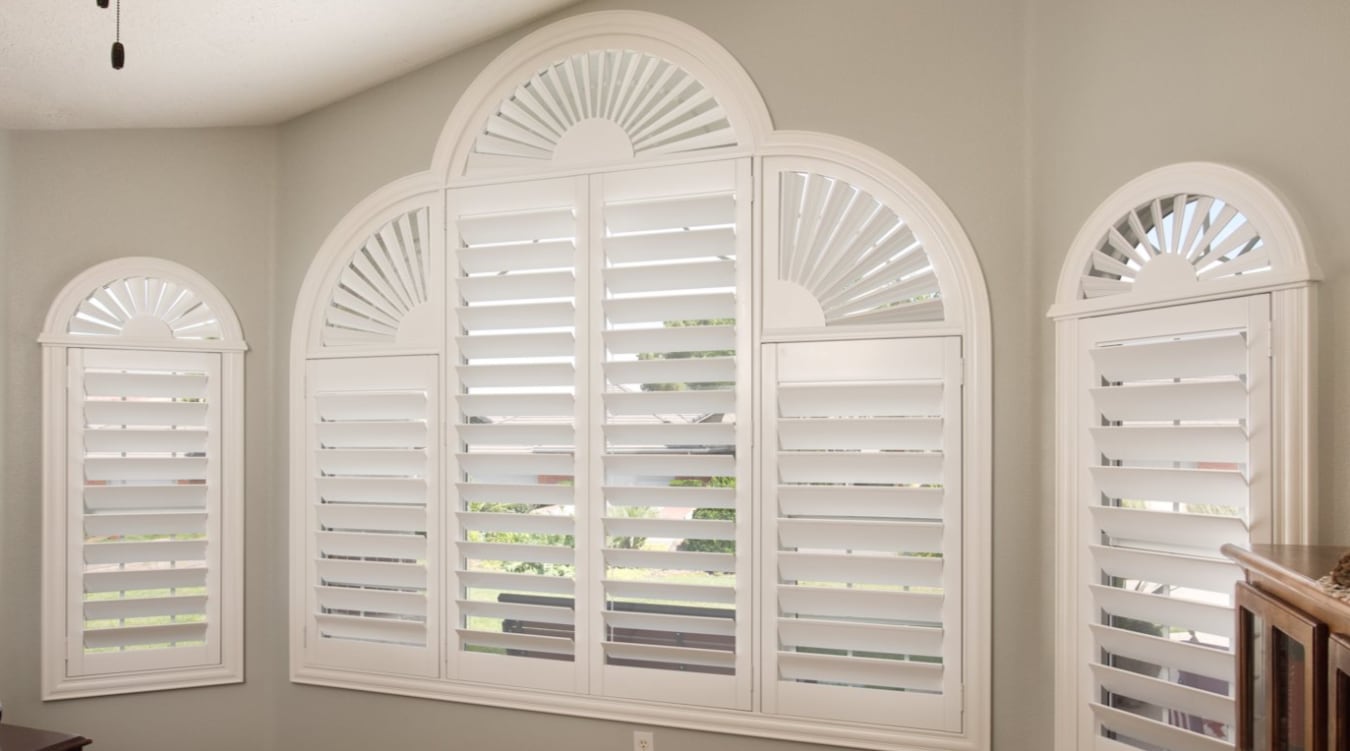 Specialty shaped windows with plantation shutters.
